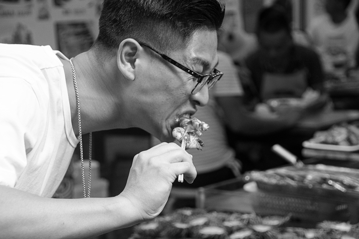 Eating spicy squid on a stick Qingdao Street Market