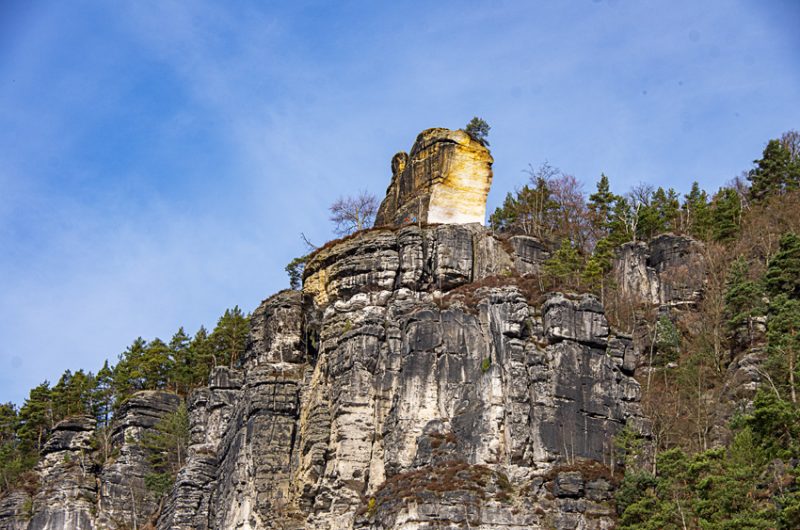 Chiseled Yellow Sandstone abutment standing high above grey sandstone cliffs.