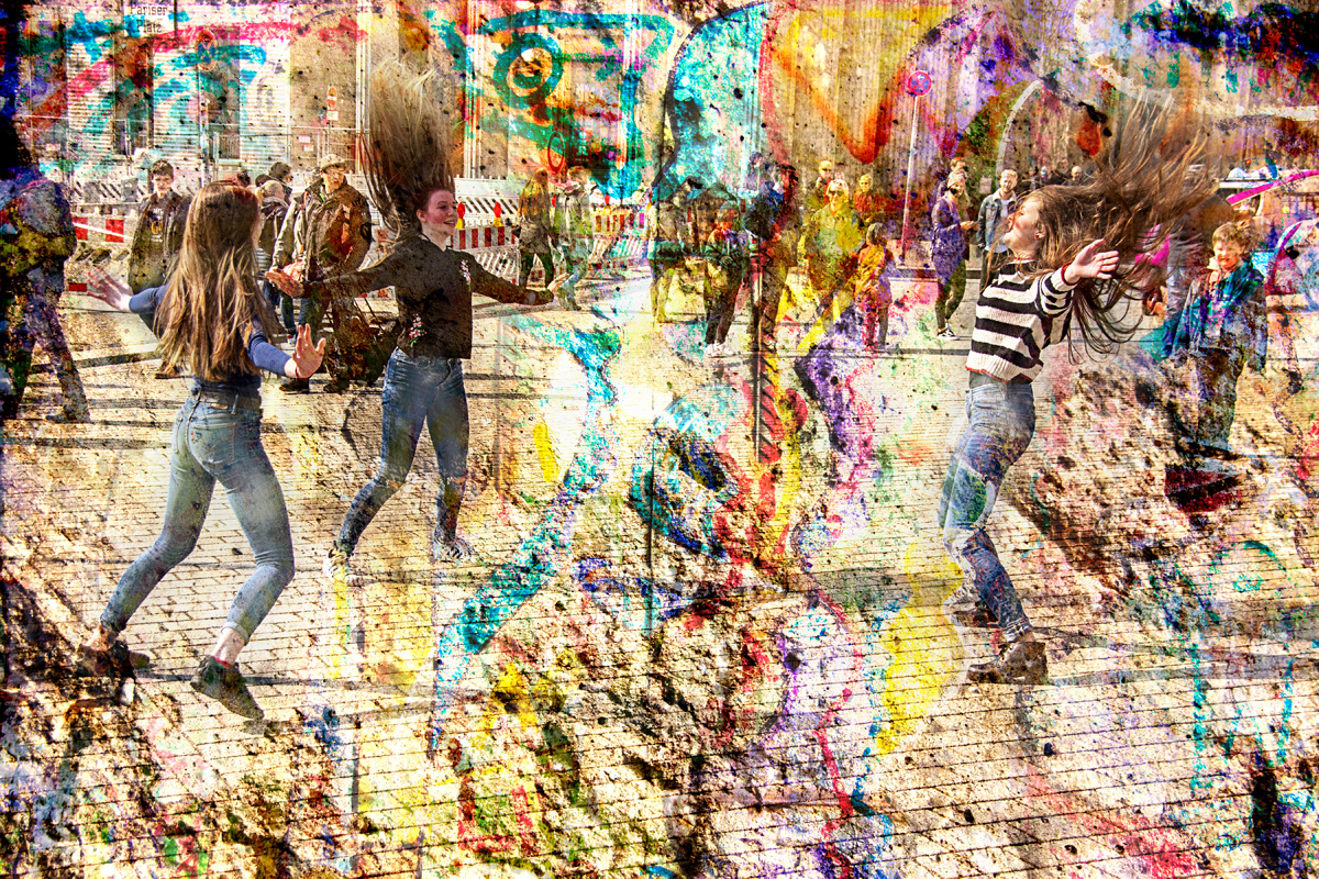 Young Girls dancing on the Eastern side of the Branderberg Gate at Easter Time with artwork from a section of the remaining Berlin Wall overlaid.