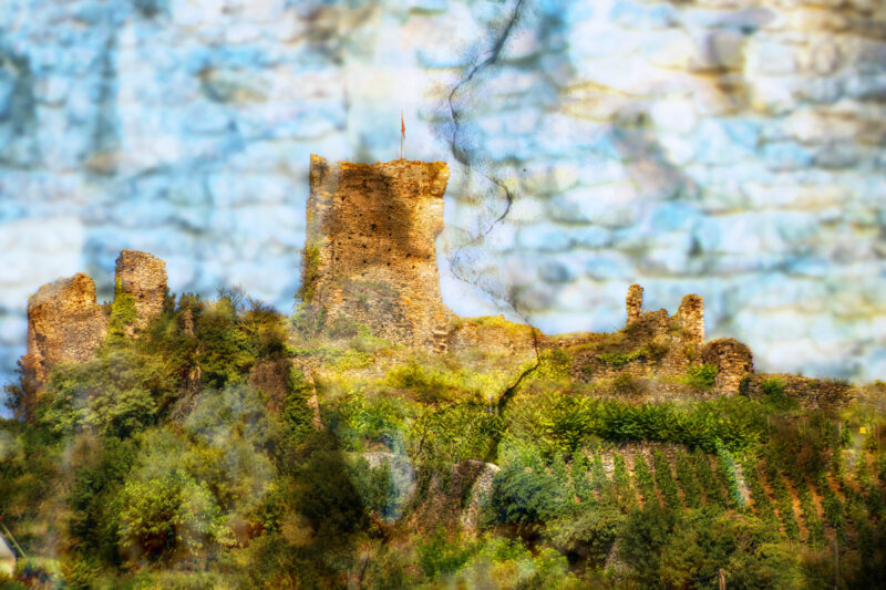 A Crack in the Textures of History- a composite photo of a the ruins of a French castle on a hillside above a vineyard.