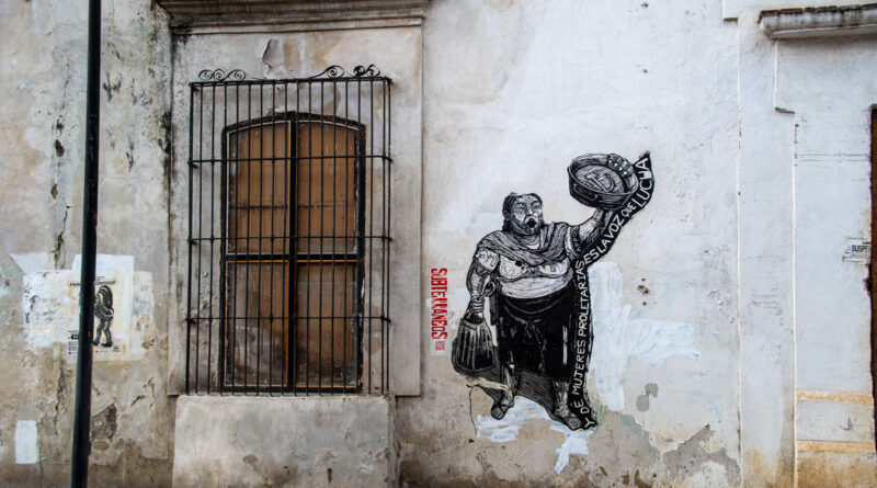 Painting on wall of a woman holding a basket. working class women are the voice of the struggle. In the style of Mexican revolutionary artists.